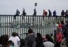 Inmigrantes intentan cruzar el muro fronterizo hacia Estados Unidos
