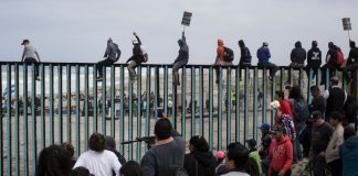 Inmigrantes intentan cruzar el muro fronterizo hacia Estados Unidos