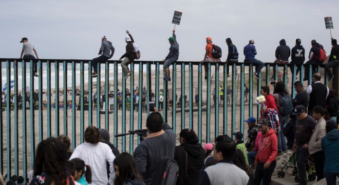 Inmigrantes intentan cruzar el muro fronterizo hacia Estados Unidos