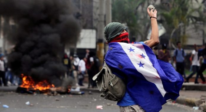 Imagen de archivo - Un jóven hondureño viste la bandera durante una manifestación en julio de 2019