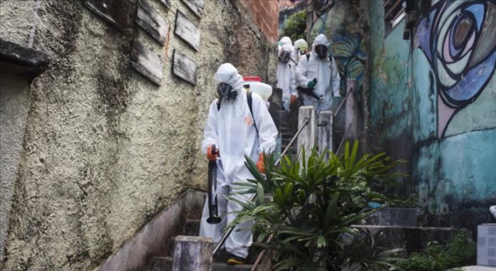 Un grupo de trabajadores de la salud desinfectan una favela en Brasil