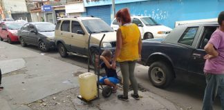 Familias recogiendo agua en las calles de Barquisimeto.