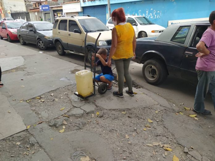 Familias recogiendo agua en las calles de Barquisimeto.