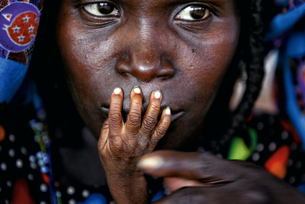 The fingers of malnourished one-year-old Galisou are pressed against the lips of his mother Ousseini at a feeding clinic in Niger