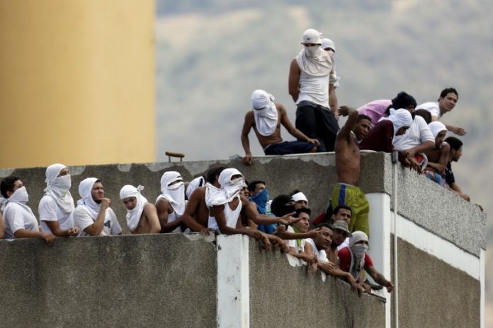 Foto de archivo: Reclusos se juntan el techo de una prisión en Caracas durante una revuelta.