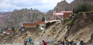 Obreros municipales trabajan cerca de casas colapsadas por la crecida de ríos en la zona Callapa, en La Paz (Bolivia). EFE/Luis Gandarillas