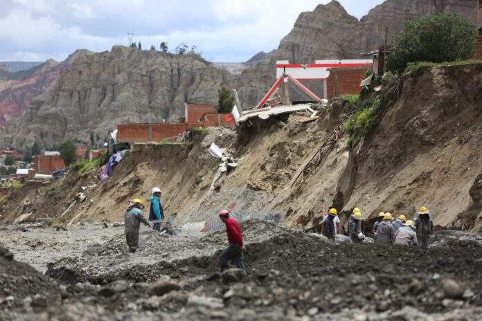 lluvias en bolivia Obreros municipales trabajan cerca de casas colapsadas por la crecida de ríos en la zona Callapa, en La Paz (Bolivia). EFE/Luis Gandarillas